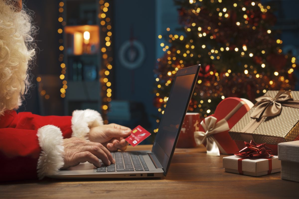 Ο Άγιος Βασίλης ψωνίζει online με φόντο το Χριστουγεννιάτικο δέντρο.